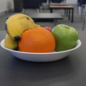 Fruit bowl on grey table.